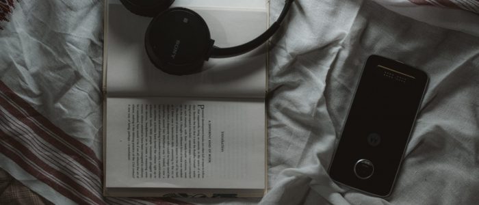Book+phone+headphones on bed